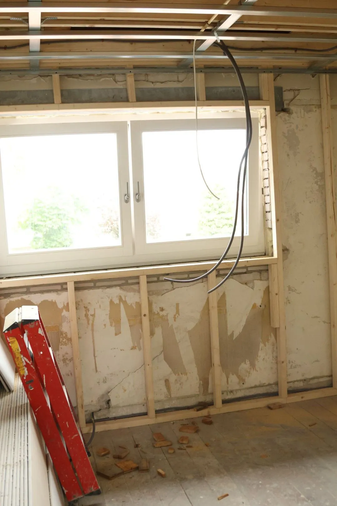 Kamer in aanbouw met nieuwe kozijnen en houten regelwerk