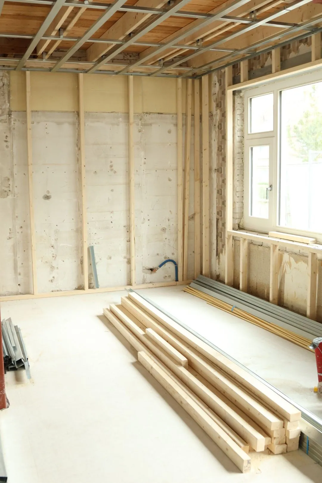 Ruimte in ruwbouw met houten wanden en balken op de vloer