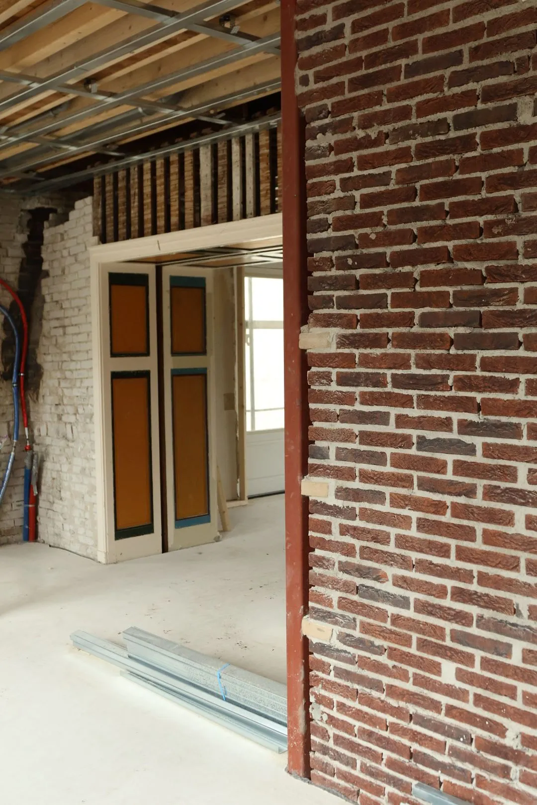 Bakstenen binnenmuur naast nieuwe deuropeningen