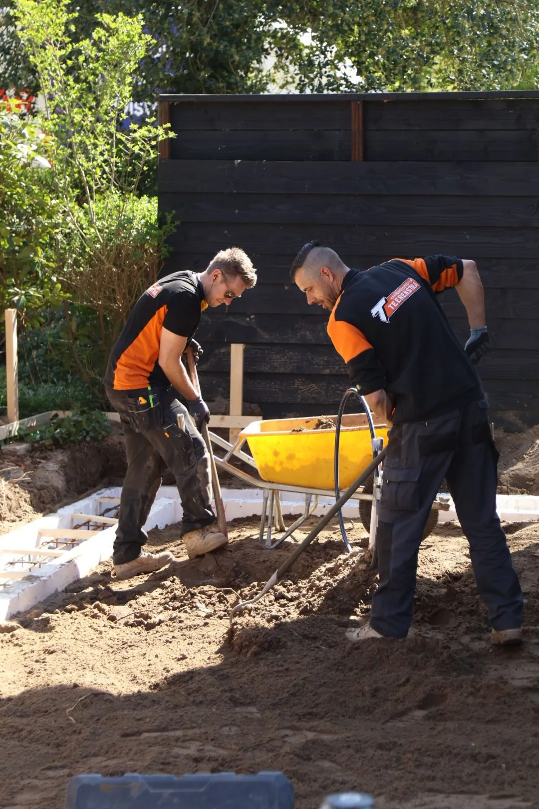 Twee vakmannen van Teerenstra aan het grondwerk met een kruiwagen